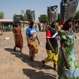 This photo taken on December 4, 2014 shows displaced women carrying sacks of food aid received during a distribution at the Cathedral of Yola, state capital of Adamawa 