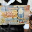 A man displays a 50,000 Kwacha note in Lusaka January 23, 2012. REUTERS/Mackson Wasamunu