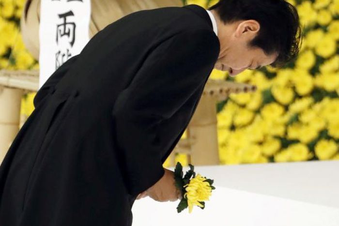 apan's Prime Minister Shinzo Abe bows as he offers a chrysanthemum flower to the war dead during a memorial service ceremony marking the anniversary of Japan's surrender in World War Two at Budokan Hall in Tokyo, Japan, in this photo taken by Kyodo Aug...