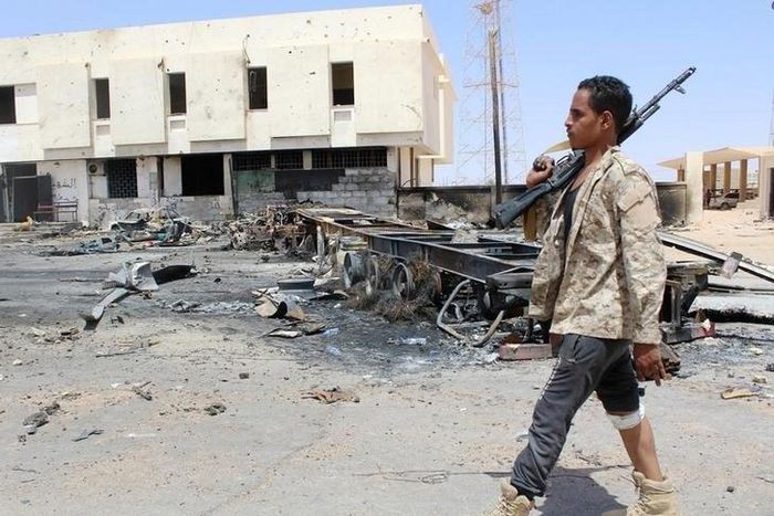 A member of the security team walks past the remains of a burnt car after a suicide car bomber hit a Libyan police station west of the besieged Islamic State stronghold of Sirte June 16, 2016. REUTERS/Stringer