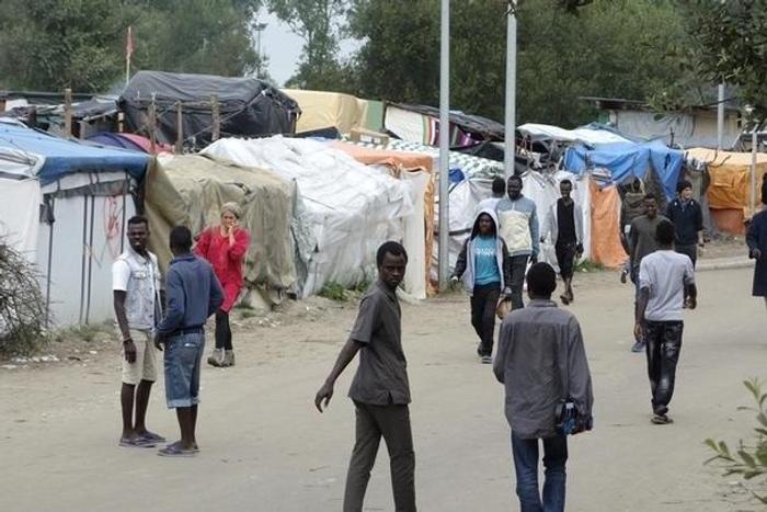 Migrants walk in the northern area of the camp called the "Jungle" in Calais, France, September 6, 2016.
