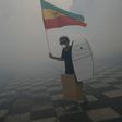 A man holds Ethiopia's former flag as he tries to prevent clashes between protesters and police during a demonstration 