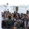 Migrants wait to disembark from a Coast Guard ship in the Sicilian harbour of Messina, Italy August 29, 2015.