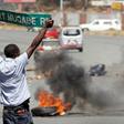 A man carries a street sign as opposition party supporters clash with police in Harare, Zimbabwe, August 26,2016. REUTERS/Philimon Bulawayo
