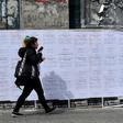 A woman walking past posters with the names of 19 women murdered by October 2018: Uruguay saw a record number of murders in 2018