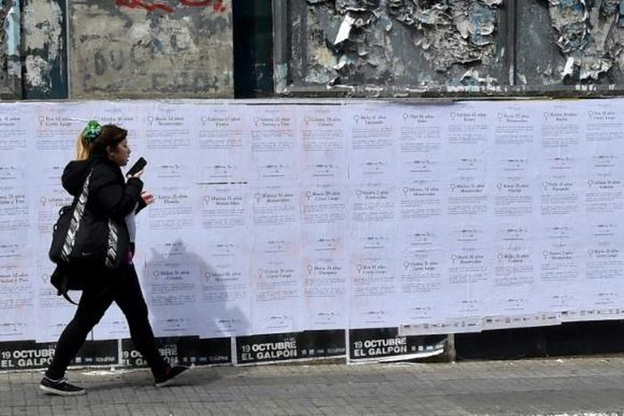 A woman walking past posters with the names of 19 women murdered by October 2018: Uruguay saw a record number of murders in 2018