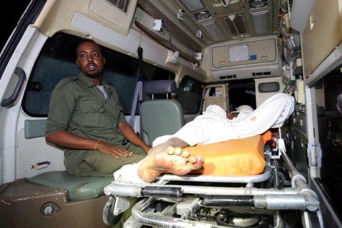 Somali policeman sits inside an ambulance as he guards an Al-Shabaab fighter injured during an exchange of gunfire after a car bomb explosion at the Banadir beach restaurant at Lido beach in Somalia's capital Mogadishu, August 25, 2016. Picture taken A...