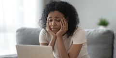 A black young woman stressed over the high costs of internet
