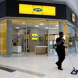 A worker sweeps past an outlet of South Africa's MTN Group in Johannesburg, February 23, 2016.