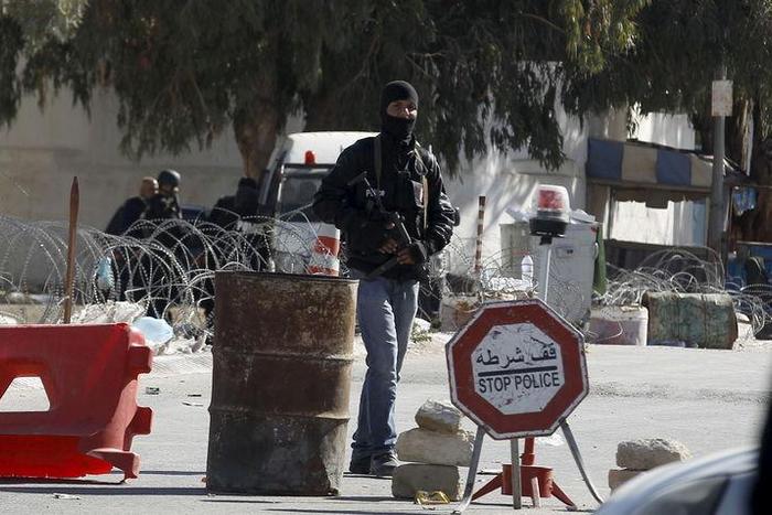A Tunisian police officer stands guard near a police station after Monday's attack by Islamist fighters on an army and police barracks in the town of Ben Guerdan, Tunisia, near the Libyan border March 8, 2016. REUTERS/Zoubeir Souissi