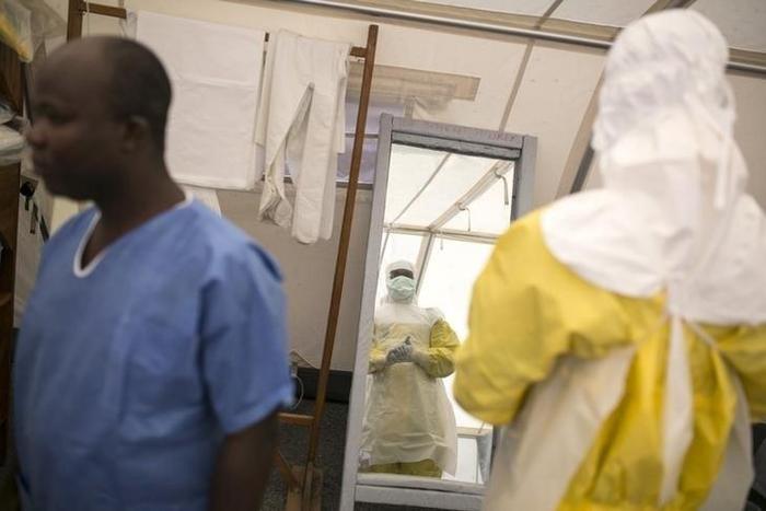 Health workers put on protective gear before entering a quarantine zone at a Red Cross facility in the town of Koidu, Kono district in Eastern Sierra Leone December 19, 2014. REUTERS/Baz Ratner