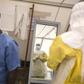 Health workers put on protective gear before entering a quarantine zone at a Red Cross facility in the town of Koidu, Kono district in Eastern Sierra Leone December 19, 2014. REUTERS/Baz Ratner