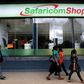 Pedestrians walk past a mobile phone care centre operated by Kenyan's telecom operator Safaricom in the central business district of Kenya's capital Nairobi, May 11, 2016.