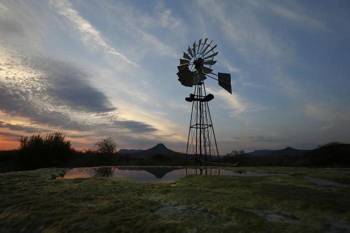 A windmill pumps water from a borehole near Graaf Reinet in the Karoo October 11, 2013. REUTERS/Mike Hutchings NG HUTCHINGS'