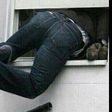 A burglar sneaking into a window