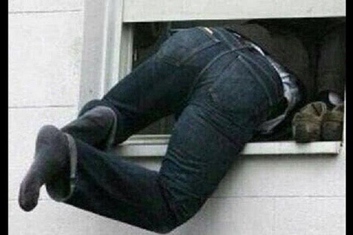 A burglar sneaking into a window