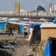 A migrant walks past makeshift shelters in the northern area on the final day of the dismantlement of the southern part of the camp called the 'Jungle" in Calais, France, March 16, 2016.