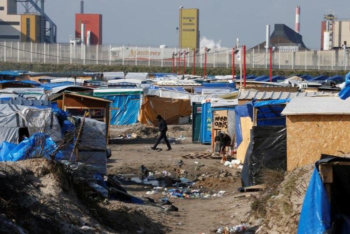 A migrant walks past makeshift shelters in the northern area on the final day of the dismantlement of the southern part of the camp called the 'Jungle" in Calais, France, March 16, 2016.