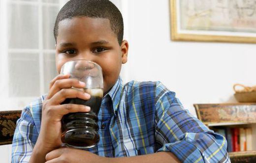Young boy drinking soda