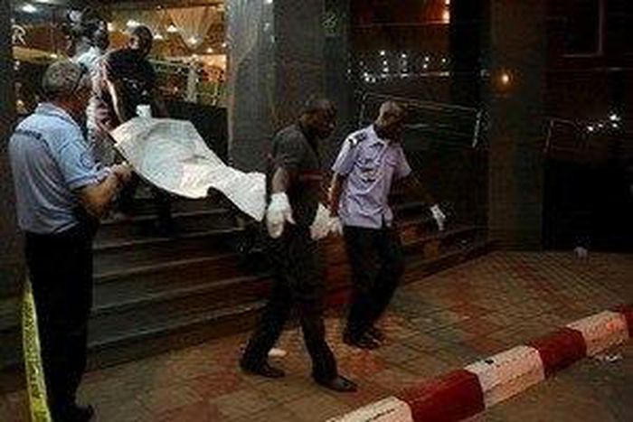 Malian officials carry a corpse outside the Radisson hotel in Bamako, Mali, November 20, 2015. REUTERS/Joe Penney