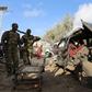 Somali policemen look at the wreckage of a car at the scene of an explosion following an attack in Somalia's capital Mogadishu, March 9, 2016. REUTERS/Feisal Omar