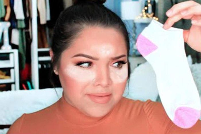 Youtuber shows how to apply foundation using socks