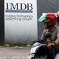 Motorcyclists pass a 1Malaysia Development Berhad (1MDB) billboard at the Tun Razak Exchange development in Kuala Lumpur, Malaysia, February 3, 2016. REUTERS/Olivia Harris/File Photo