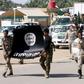 Shi'ite paramilitary fighters hold an Islamist State flag which they pulled down during victory celebrations after returning from Tikrit in Kerbala, southwest of Baghdad April 4, 2015.    REUTERS/Mushtaq Muhammed
