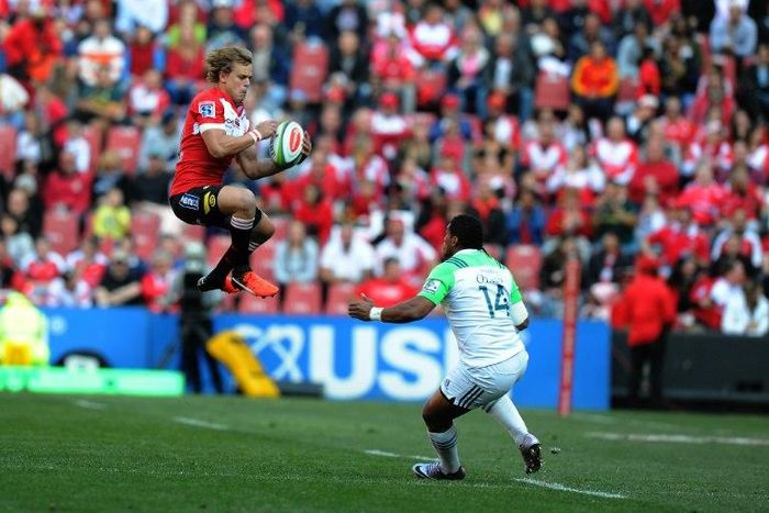 Lions' Andries Coetzee jumps with the ball past Highlanders' Waisake Naholo at Ellis Park on July 30, 2016 in Johannesburg, South Africa
