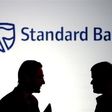 Businessmen chat in front of a Standard Bank logo in Sandton outside Johannesburg,  file.   REUTERS/Siphiwe Sibeko