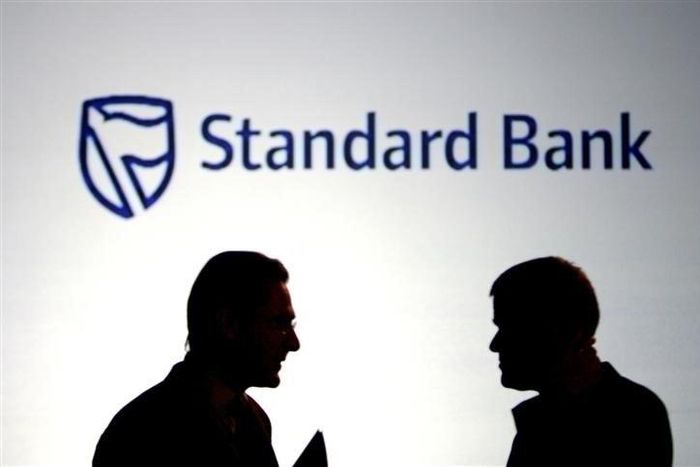 Businessmen chat in front of a Standard Bank logo in Sandton outside Johannesburg,  file.   REUTERS/Siphiwe Sibeko
