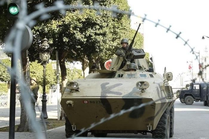 An army soldier stands guard behind a wire fence cordon outside the interior minister's office in Tunis February 7, 2011. REUTERS/Zoubier Souissi