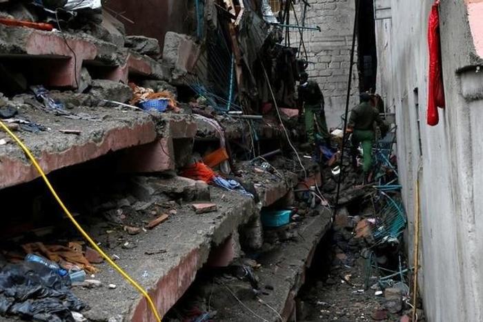 Rescue workers search for residents feared trapped in the rubble of a six-storey building that collapsed after days of heavy rain in Nairobi, Kenya, May 1, 2016.