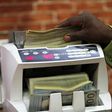 A bureau de change operator counts U.S. currency notes in Abuja, March 12, 2015. In Nigeria, holding naira has become increasingly unpopular as it has lost its value. Basic everyday goods can still be paid for in the local currency but many items are s...