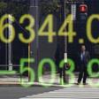 A businessman is reflected in an electronic board displaying Japan's Nikkei share average outside a brokerage in Tokyo, Japan, April 18, 2016.