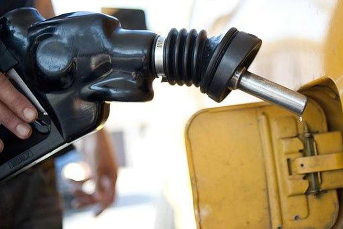 A picture of a fuel attendant filling up a customer's tank.