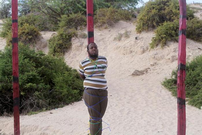 Hassan Hanafi, a former media officer for the Somali Islamist group al Shabaab, stands tied to a pole before his execution by shooting at close range on a field in General Kahiye Police Academy in Somalia's capital Mogadishu, April 11, 2016.