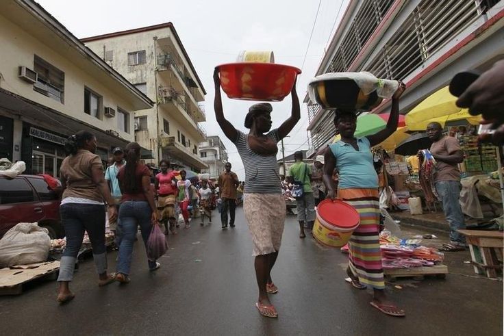 People walk along a street market in Monrovia October 13, 2011.