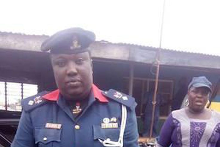 An NSCDC officer holding the boy