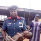 An NSCDC officer holding the boy
