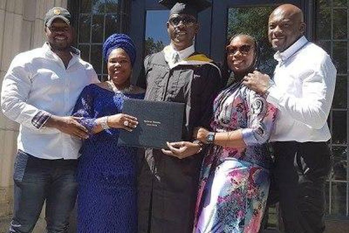 Musiliu Obanikoro flanked by his wife and children at his graduation