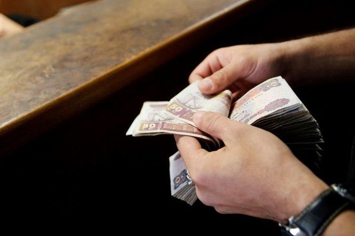 A customer counts his Egyptian 50 pound notes at an exchange office in downtown Cairo, Egypt, April 19, 2016. REUTERS/Amr Abdallah Dalsh