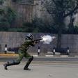 A riot policeman fires a teargas canister to disperse supporters of Kenya's opposition Coalition for Reforms and Democracy (CORD) during a protest at the premises hosting the headquarters of Independent Electoral and Boundaries Commission (IEBC) to dem...