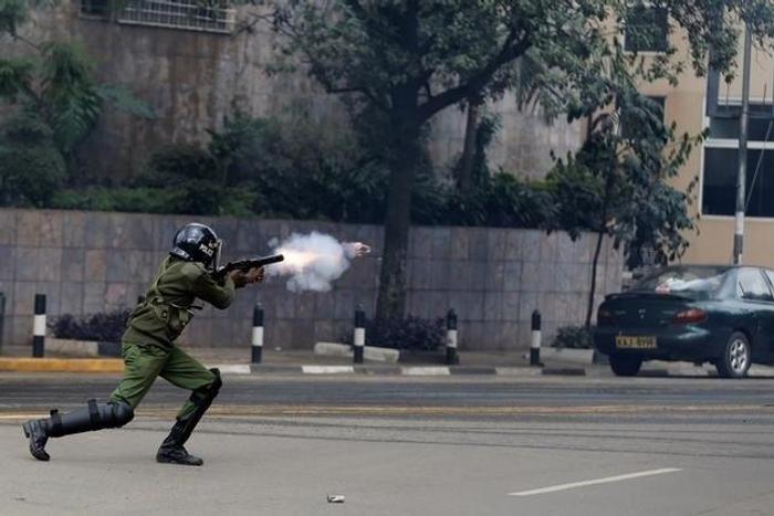 A riot policeman fires a teargas canister to disperse supporters of Kenya's opposition Coalition for Reforms and Democracy (CORD) during a protest at the premises hosting the headquarters of Independent Electoral and Boundaries Commission (IEBC) to dem...