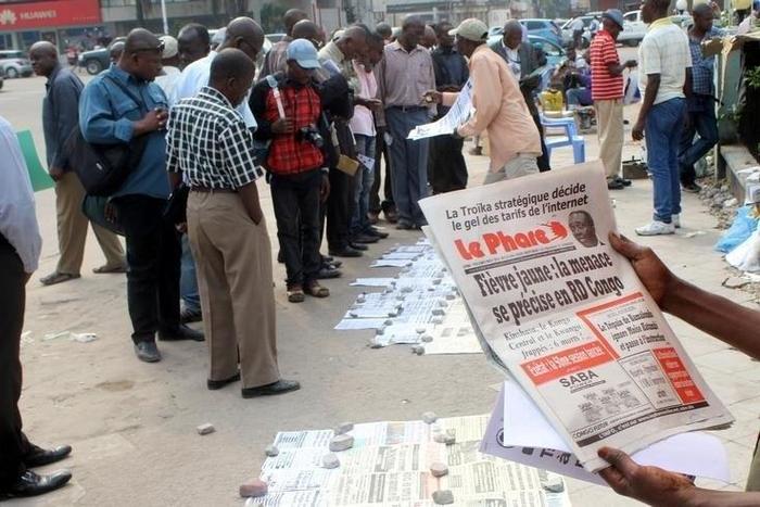 Residents read newspapers with reports of Yellow Fever, along the streets in Kinshasa, capital of the Democratic Republic of the Congo, June 21, 2016. REUTERS/Jean Robert N'kengo
