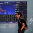 A man walks in front of a screen showing today's movements of Nikkei share average outside a brokerage in Tokyo, Japan, June 2, 2016.