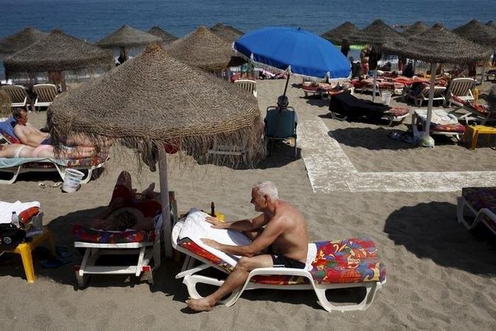 Tourists sunbathe on a beach in Fuengirola, on Costa del Sol, southern Spain, July 12, 2015.
