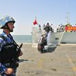 A navy soldier (L) of People's Liberation Army (PLA) stands guard as Chinese citizens board the naval ship "Linyi" at a port in Aden, in this March 29, 2015 file photo. REUTERS/Stringer/Files