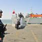 A navy soldier (L) of People's Liberation Army (PLA) stands guard as Chinese citizens board the naval ship "Linyi" at a port in Aden, in this March 29, 2015 file photo. REUTERS/Stringer/Files
