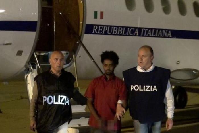 Medhanie Yehdego Mered (C), 35, is pictured with Italian policemen as they land at Palermo airport, Italy, following his arrest in Khartoum, Sudan, on May 24.   REUTERS/File Photo